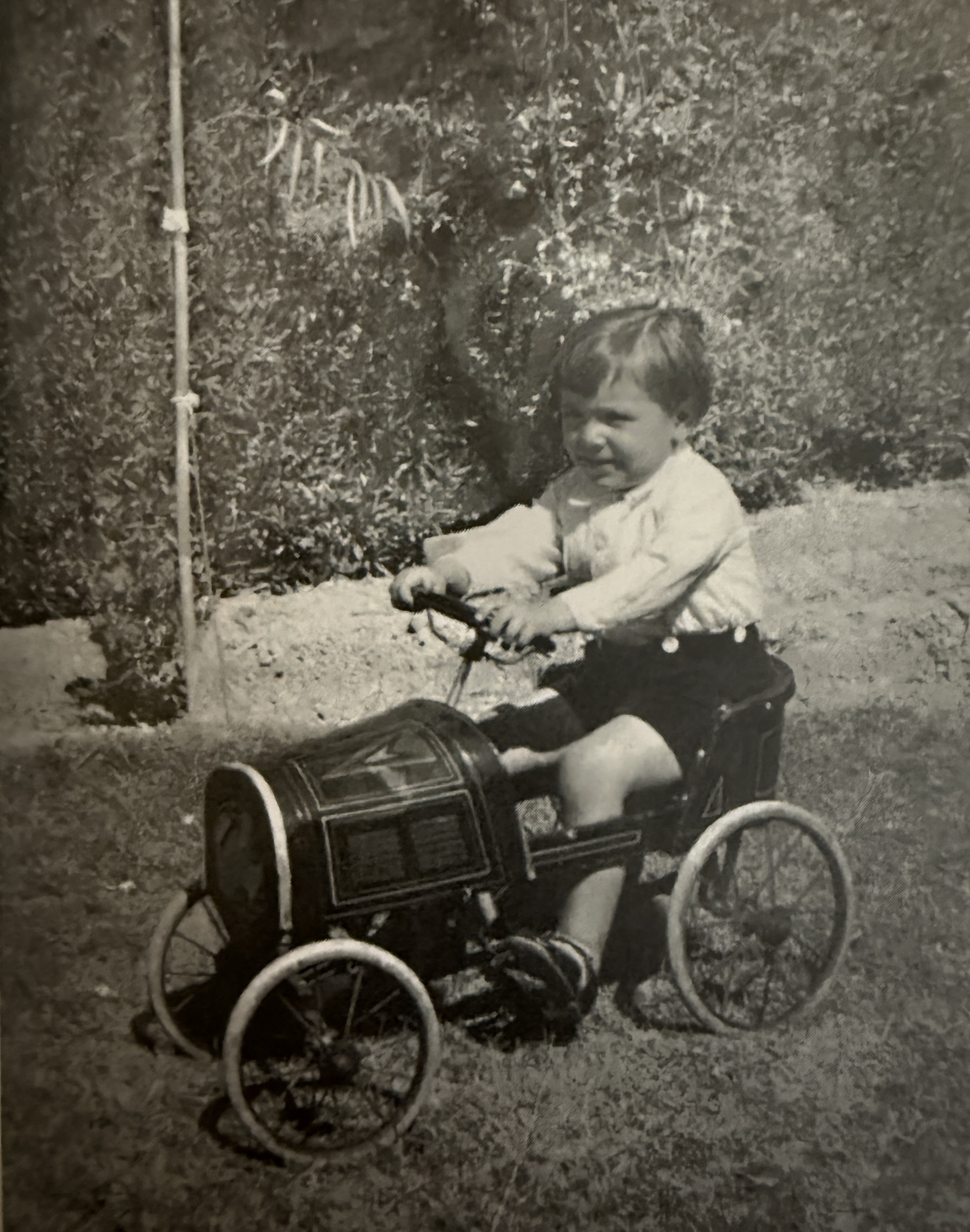 A young child Sasson Somekh on a toy pedal car, Baghdad