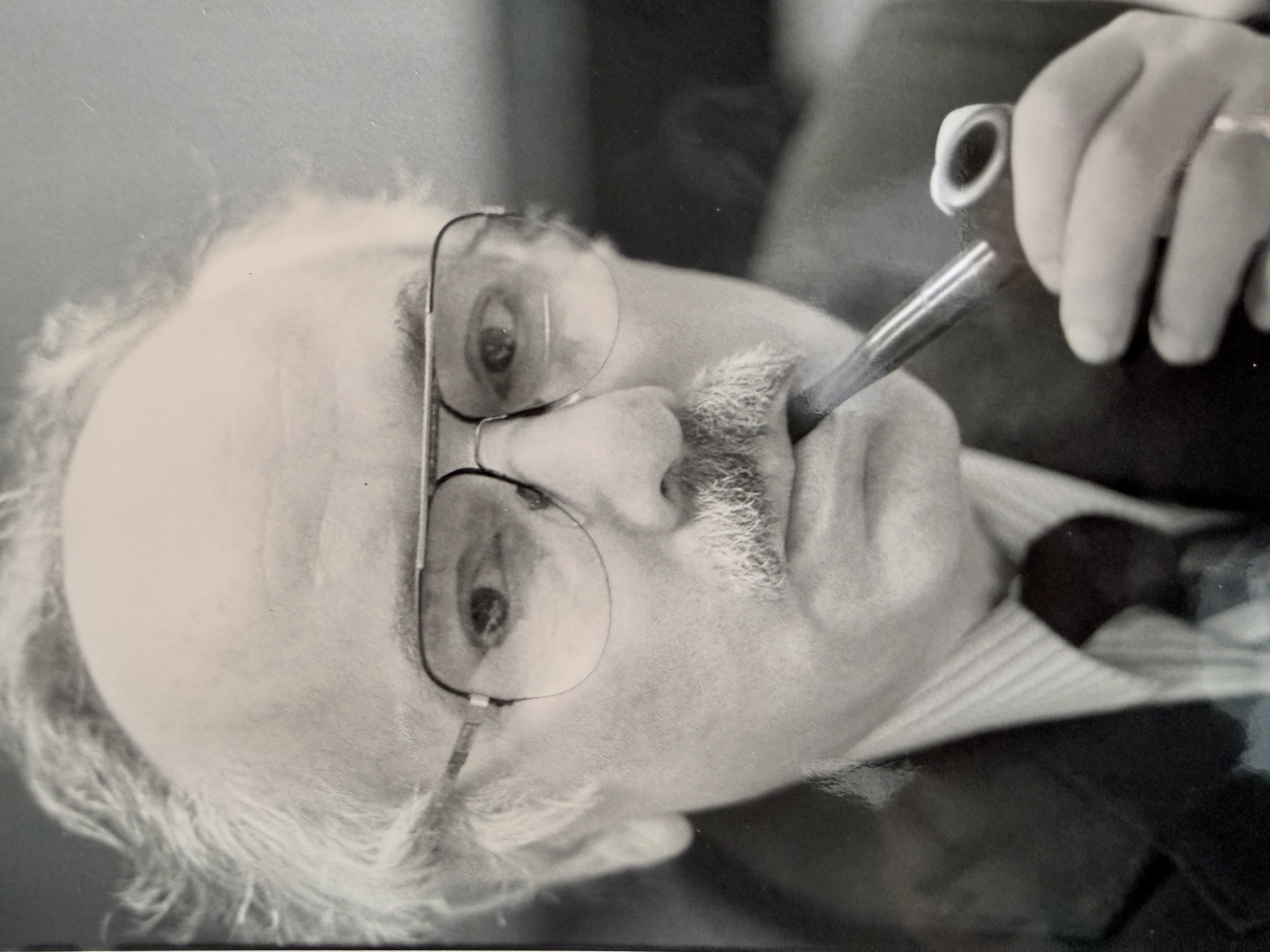 A close portrait of Sasson Somekh smoking a pipe